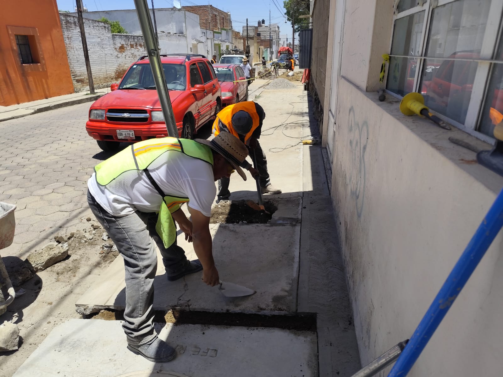 Equipo reparando banqueta y línea de instalación